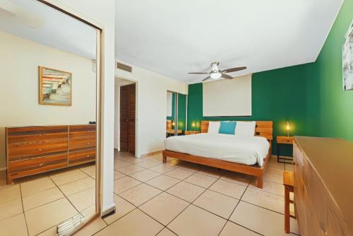 una camera da letto con un letto e una parete verde di Waterside Flat With Garage And Easy Beach Access a San Juan