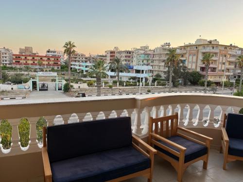 a balcony with two chairs and a view of a city at فندق ألماسه جمصه in Jamaşah