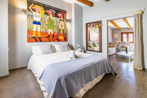 ein Schlafzimmer mit einem Bett und einem großen Gemälde an der Wand in der Unterkunft En el corazon de Palma by Mallorca Infinity in Palma de Mallorca