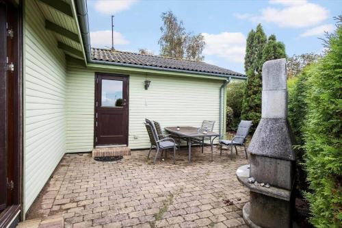 a patio with a table and chairs in front of a house at FY267-Faaborg-Horsehoved-37 in Fåborg