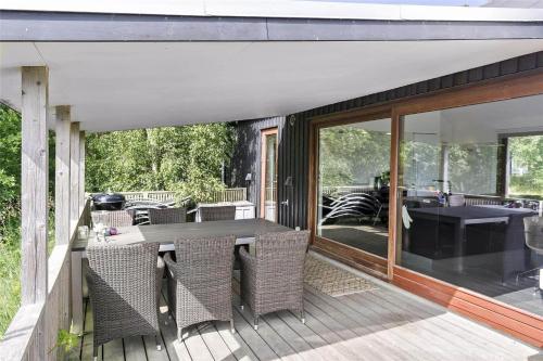 a patio with a table and chairs on a deck at 1328-Aakirkeby-Poserevaenget-34 in Vester Sømarken