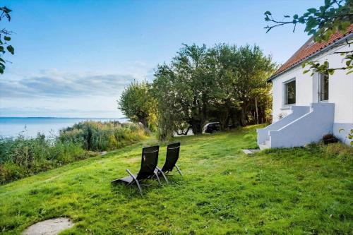 two chairs sitting in the grass next to a house at FY297-Faaborg-Ostergyden-37 in Nabbe