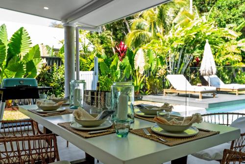 a table with plates of food on a patio at Belle Escapes Casa Yule in Clifton Beach