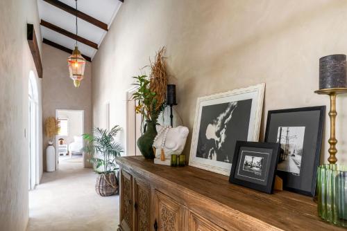 a living room with a wooden table with pictures on it at Belle Escapes Casa Yule in Clifton Beach