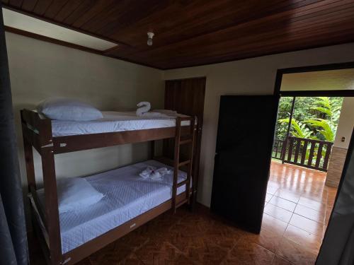 two bunk beds in a room with a balcony at Cabinas Las Chinitas in Zapotal