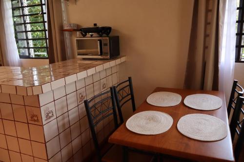 a kitchen with two wooden tables and a microwave at Cabinas Las Chinitas in Zapotal