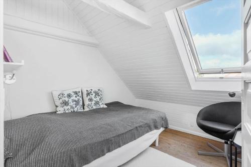a bedroom with a bed and a window and a chair at FY245-Assens-Ramsherred-25 in Assens
