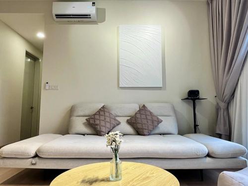 a living room with a couch and a table at Calm MUJI-Inspired Home - Stunning Sunset View - Steps To IOI City Mall - Your Best Urban Retreat in Putrajaya