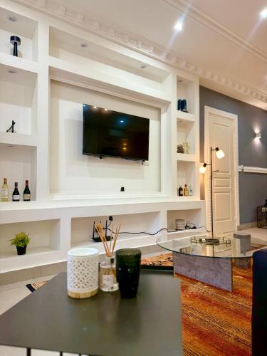 a kitchen with a table with a television on a wall at Duende in Pointe-Noire