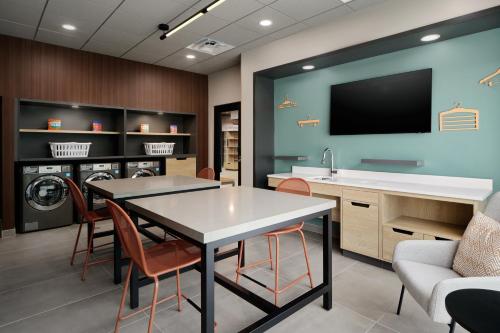 a laundry room with a table and chairs and a tv at LivSmart Studios By Hilton Tullahoma in Tullahoma