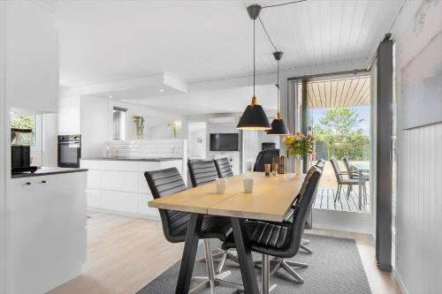 a kitchen and dining room with a wooden table and chairs at FY147-Middelfart-Antaresvej-6 in Middelfart