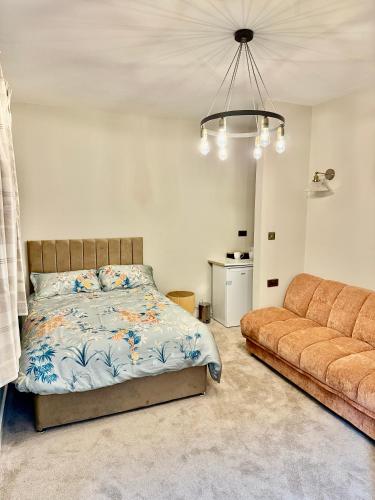 a bedroom with a bed and a couch at Double Deluxe Centre Apartment- Free Parking - Self Check-In - Cctv in Huddersfield