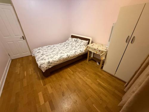 a small bedroom with a bed and a table at Lovely private Room in London