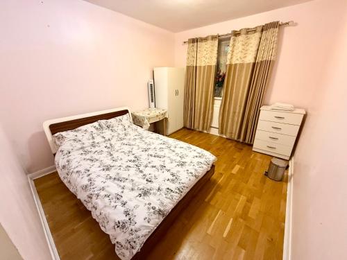a bedroom with a bed and a dresser in it at Lovely private Room in London