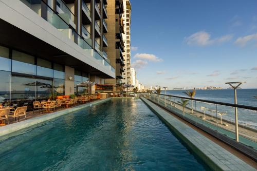 a hotel swimming pool with a view of the ocean at Holiday Inn Express & Suites Mazatlan by IHG in Mazatlán