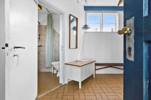 Un baño con inodoro, lavabo y ventana. en 5599-Gudhjem-Grevens-Dal-2, en Gudhjem