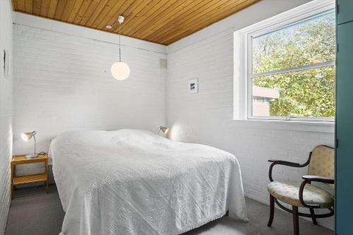 een slaapkamer met een bed, een stoel en een raam bij LF15143-Hojslev-Mosevej-143 in Højslev