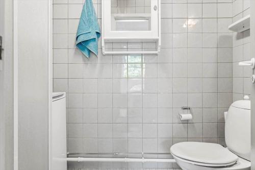 een witte badkamer met een toilet en een blauwe handdoek bij LF15143-Hojslev-Mosevej-143 in Højslev