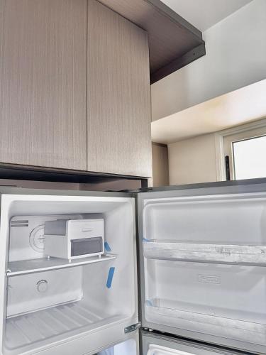 a kitchen with an open refrigerator with a toaster at Pool View & Direct Access Margarita Island in Porlamar