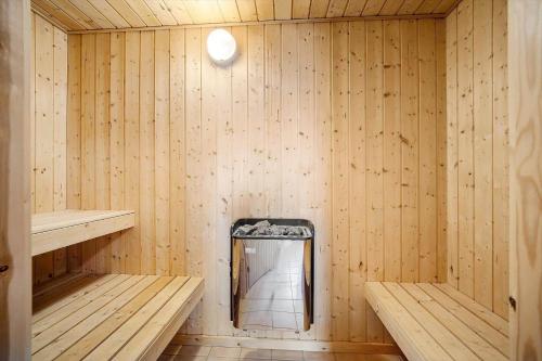a wooden sauna with two benches and a mirror at FY300-Faaborg-Mosegarden-43 in Bogentved