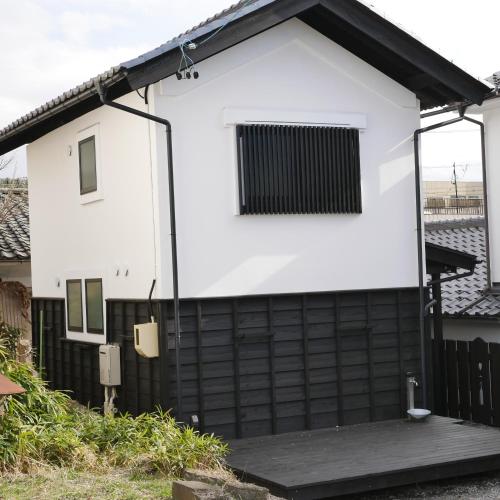 a white and black house with a black fence at Vacation House YORAKURA よら蔵 in Komoro
