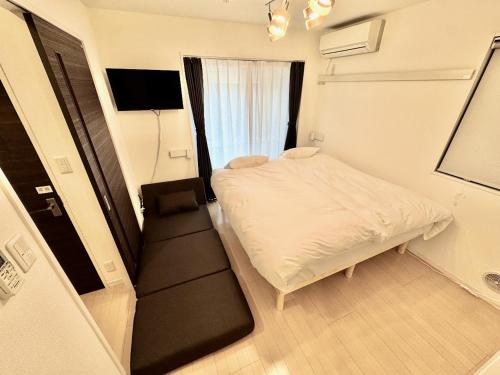 a small room with a bed and a window at Capital Shimbashi 101, Studio in Tokyo