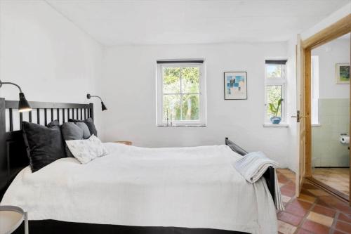 a bedroom with a large bed with white sheets at FY252-Haarby-Brunshusevej-23 in Hårby