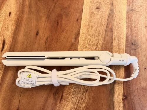 a white cord wrapped around a remote control on a wooden floor at Capital Shimbashi 101, Studio in Tokyo