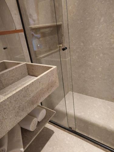 un bagno con doccia in vetro con rotoli di carta igienica di Apt 01 quarto Resort Salinas Premium a Salinópolis