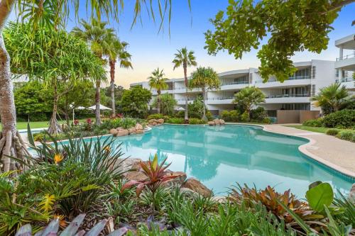 a swimming pool in front of a building at Cotton Beach 97 Luxurious Mid Floor Apartment in Casuarina