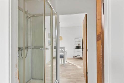 a glass shower in a room with a desk at 727-Thyboron-Magevej-10 in Thyborøn
