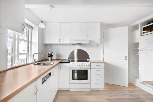 a white kitchen with white cabinets and a sink at FY344-Dalby-Fynshovedvej-344 in Dalby