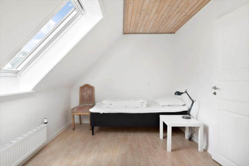 a bedroom with a bed and a chair in a attic at FY344-Dalby-Fynshovedvej-344 in Dalby