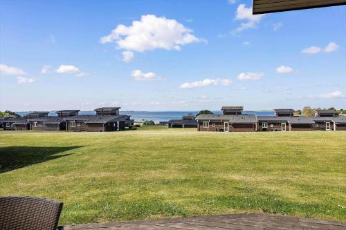 a large yard with houses and the ocean in the background at FY291-Faaborg-Mosegarden-44 in Bogentved