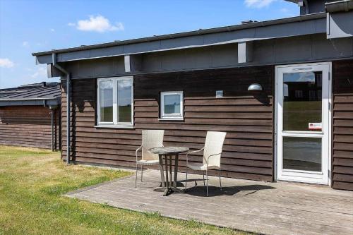 a house with a table and chairs in front of it at FY291-Faaborg-Mosegarden-44 in Bogentved