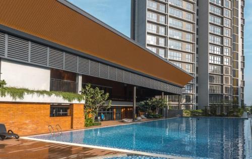 a swimming pool in front of a tall building at Calm MUJI-Inspired Home - Stunning Sunset View - Steps To IOI City Mall - Your Best Urban Retreat in Putrajaya