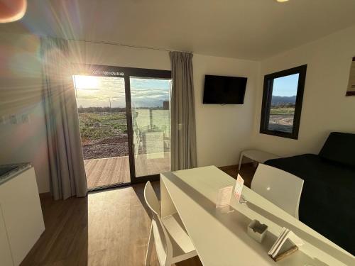 a small living room with a table and a bed and a window at Eco Lodge - Campos de artaza in Belén