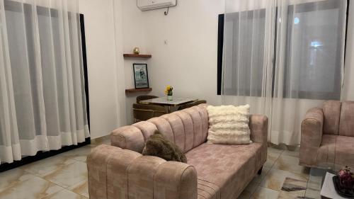 a cat sitting on a couch in a living room at MiniGolf, MeteoMode & B2B RESIDENCE Ekoumdoum - DAHARA APPARTS in Yaoundé