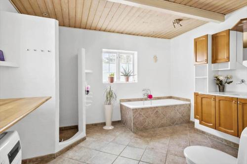 a bathroom with a bath tub and a sink at FY283-Broby-Sandholtvej-45 in Sandholts-Lyndelse