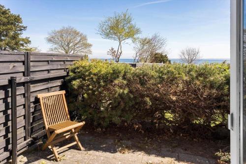 a wooden chair sitting in front of a fence at FY316-Hesselager-Syrenvej-8 in Hesselager