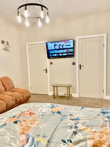 a living room with a couch and a tv at Double Deluxe Centre Apartment- Free Parking - Self Check-In - Cctv in Huddersfield
