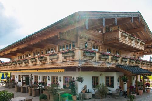a large wooden building with a balcony at Winklmoos Sonnenalm in Reit im Winkl