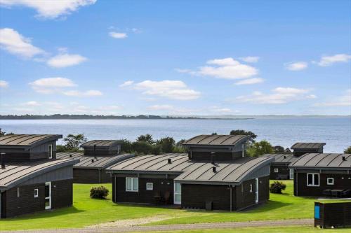 a row of cottages in front of the water at FY295-Faaborg-Mosegarden-39 in Nabbe