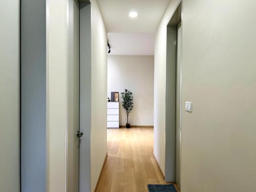an open hallway with white walls and wooden floors at Calm MUJI-Inspired Home - Stunning Sunset View - Steps To IOI City Mall - Your Best Urban Retreat in Putrajaya