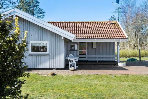 a small house with a chair in front of it at FY137-Middelfart-Altairvej-17 in Middelfart