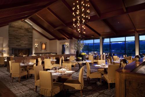 a dining room with tables and chairs and windows at Rosewood Sand Hill in Menlo Park