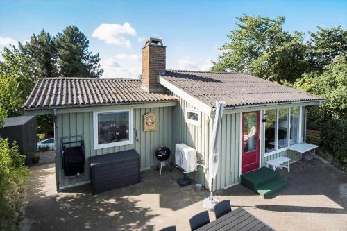 a small green house with a red door at FY155-Middelfart-Daemningen-99 in Middelfart