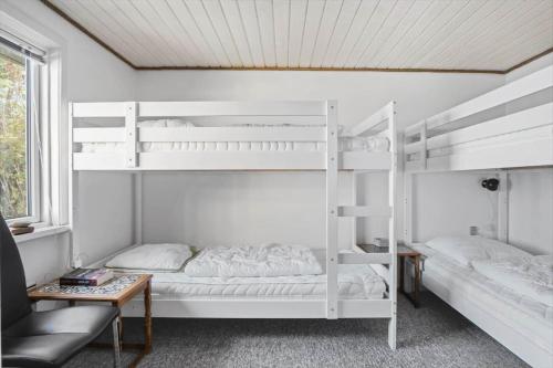 a room with two bunk beds and a table at FY155-Middelfart-Daemningen-99 in Middelfart