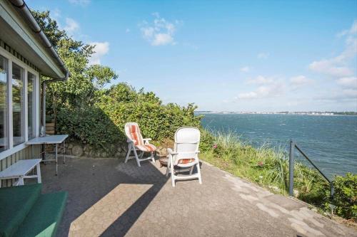 two chairs and a table on the side of a house at FY155-Middelfart-Daemningen-99 in Middelfart