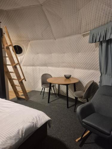 a room with a bed and a table and chairs at Glamping Agro Marzenie in Krajno Pierwsze